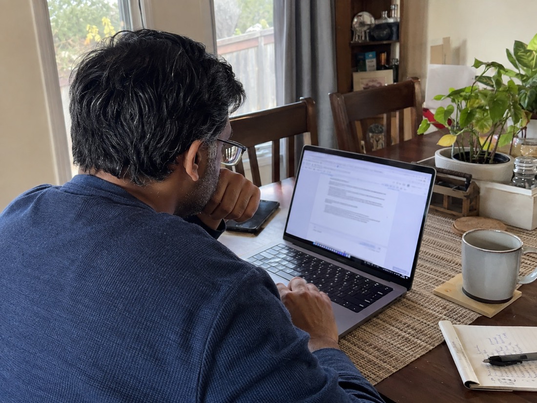 Person reviewing job search materials while using a laptop