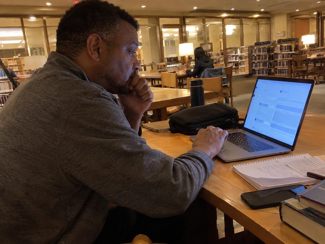 Person using a laptop and notes during a job search