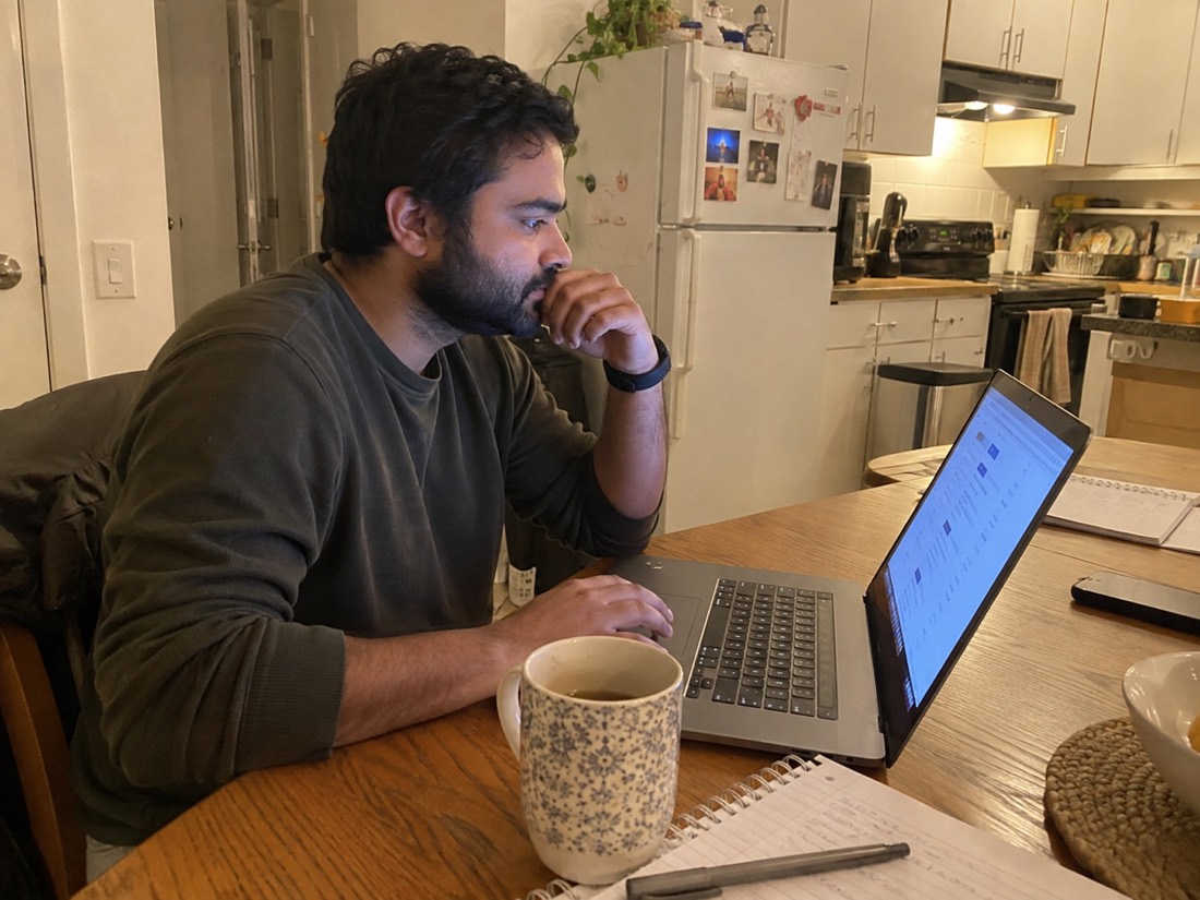 Person reviewing job search materials while using a laptop