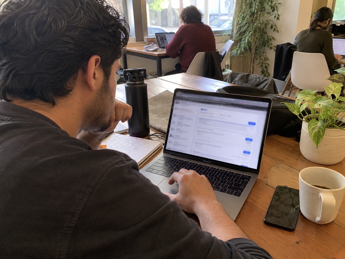 Person using a laptop and notes during a job search
