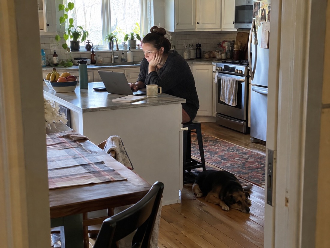 Person reviewing job search materials while using a laptop