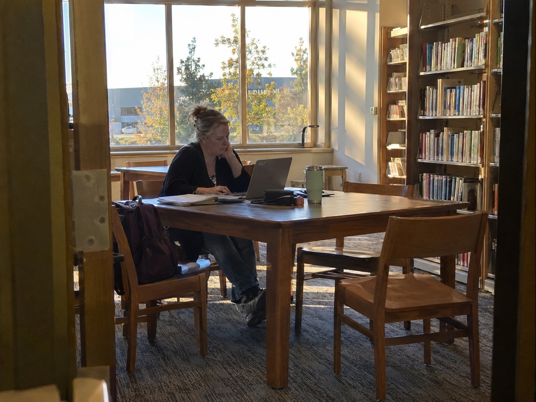 Person reviewing job search materials while using a laptop