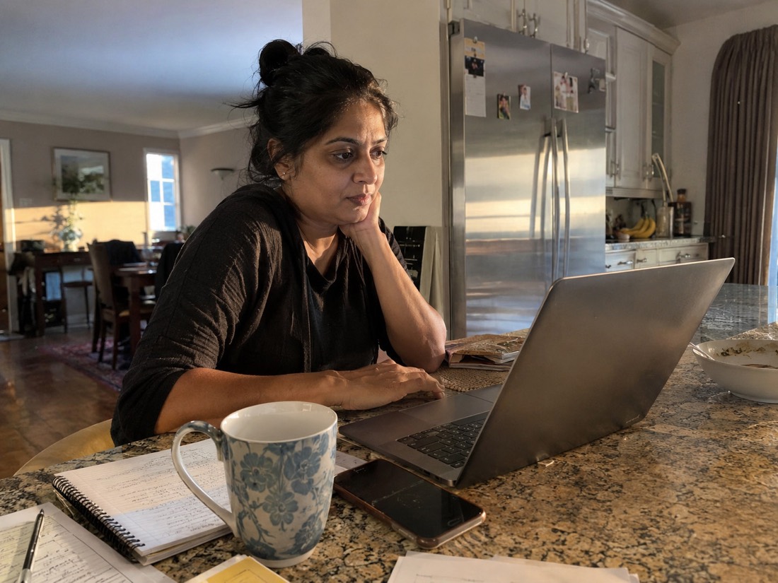 Person reviewing job search materials while using a laptop