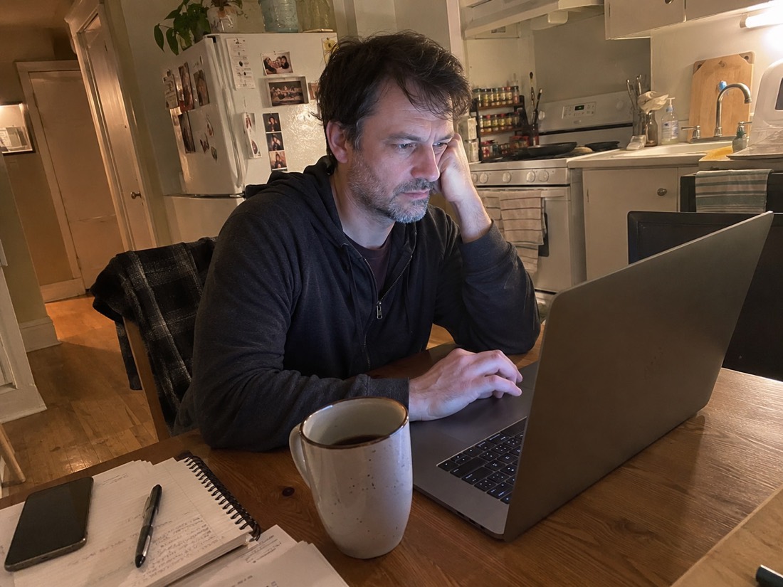 Person reviewing job search materials while using a laptop