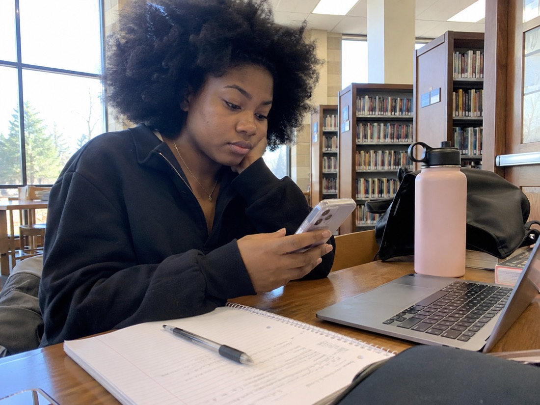 Person reviewing job search materials while using a laptop