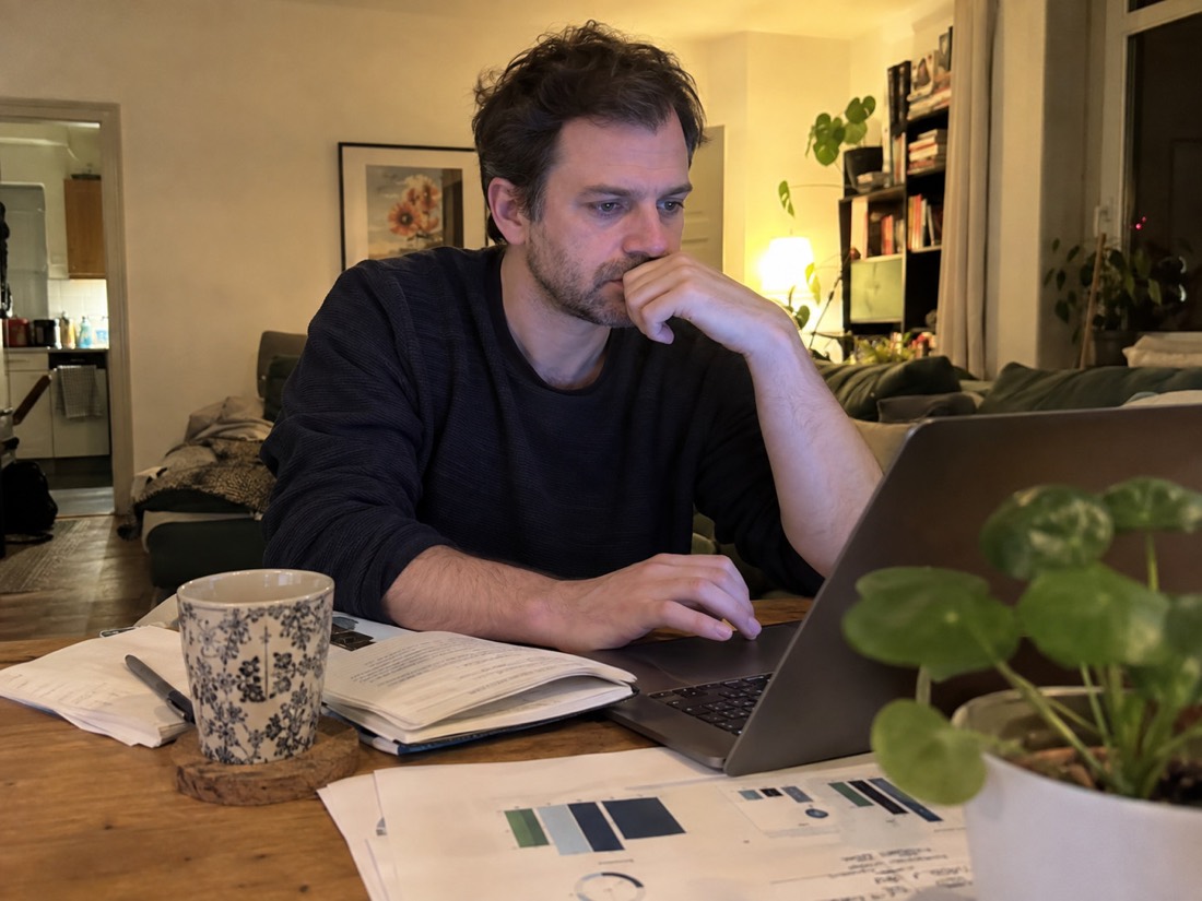 Person planning a job search at a table with a laptop and notebook