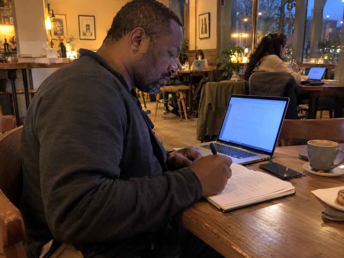 Person using a laptop and notes during a job search